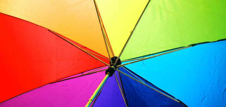 Aufgespannter Regenschirm in Regenbogenfarben.